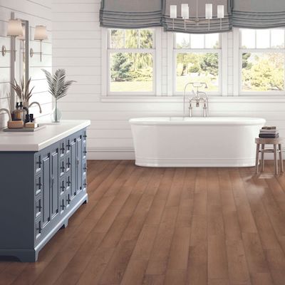 bathroom remodel with beautiful wood look floors, vanity, and tub with large windows